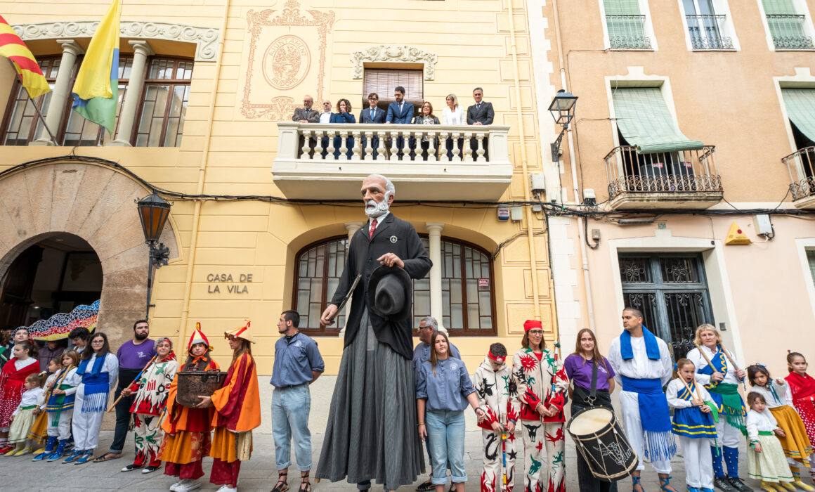 Un gigante de Antonio Gaudí acompañado por diversos danzantes con ropas coloridas