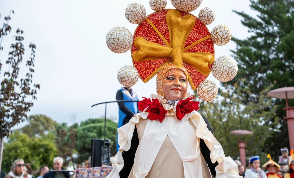 Una mujer lleva un colorido tocado que sigue el patrón del trencadís, con piezas de mosaico.